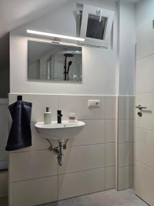 a white bathroom with a sink and a mirror at Aluston in Hannover