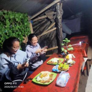 two women sitting at a table with plates of food at Batur Sunrise Tent in Kubupenlokan +7 photos