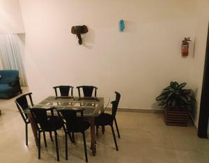 a dining room with a glass table and chairs at The Thekkady Haritham Residency in Thekkady