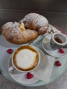 a plate with two pastries and a cup of coffee at La Mora Rooms in Linguaglossa