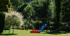 einen Spielplatz in einem Park mit Rutsche und Schaukeln in der Unterkunft Gasthaus Finken in Oppenau