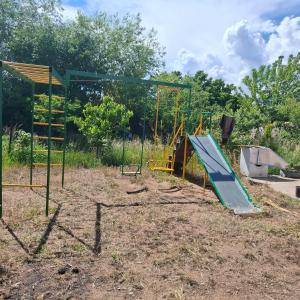 a playground with a blue slide and a swing at Гостевой дом in Cholpon-Ata