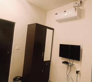 a room with a black cabinet and a flat screen tv at The Thekkady Haritham Residency in Thekkady