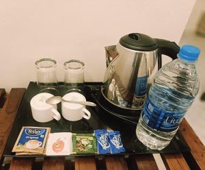 a tray with a coffee maker and a bottle of water at The Thekkady Haritham Residency in Thekkady +16 photos