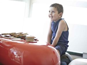 a young boy sitting on a toy car at Novotel Yanbu Albahr in Yanbu