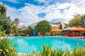 a pool at a resort with tables and umbrellas at Paradise Garden Hotel and Convention Center Boracay Powered by ASTON in Boracay