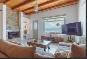 a living room with a fireplace and a tv at Morning glow villa in Antiparos