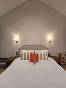 a teddy bear sitting on top of a large bed at DRIZZLE pool and pillows in Phra Khanong