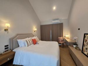 a bedroom with a large white bed and a couch at DRIZZLE pool and pillows in Phra Khanong