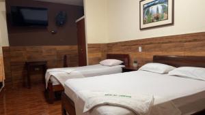 a hotel room with two beds and a flat screen tv at Hospedaje Maju Del Oriente in Pucallpa