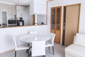a kitchen and dining room with a white table and chairs at 星空テラスと海一望 静寂に包まれる屋上BBQ Resort Villa ManMaka in Miyakojima