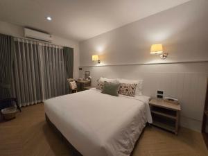 a bedroom with a large white bed and two lamps at DRIZZLE pool and pillows in Phra Khanong
