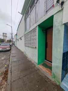 ein grünes Gebäude mit einer Holztür an einer Straße in der Unterkunft Casona Don Nilo in Morelia