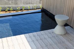 a toilet sitting on a deck next to a swimming pool at DEAR MOM - Hotel & Cafe in Onjuku