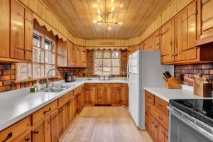a kitchen with wooden cabinets and a white refrigerator at Beartop Lodge Cozy Rustic Cabin Fire Pit in Blakeslee