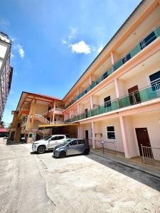 two cars parked in a parking lot in front of a building at Amzar Motel Cenang in Pantai Cenang +46 photos