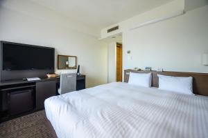 a hotel room with a bed and a flat screen tv at KKR Hotel Nagoya in Nagoya