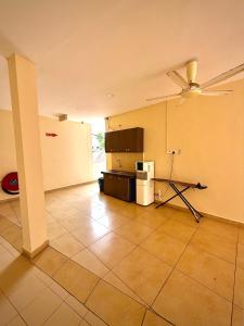 an empty room with a kitchen with a ceiling fan at Amzar Motel Cenang in Pantai Cenang
