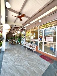 a restaurant with chairs and tables and a ceiling fan at Amzar Motel Cenang in Pantai Cenang