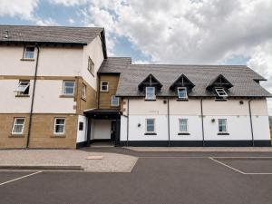 a large white building with a black roof at Morlich Guesthouse in Dingwall