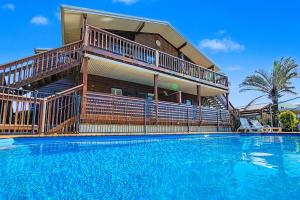 a house with a large swimming pool in front of a house at Boat Harbour Stays in Hervey Bay