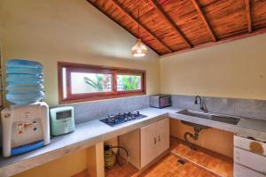 a kitchen with a sink and a counter with a window at Aruna House in Ubud