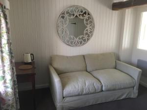 a living room with a couch and a mirror at Penylan Barn in Hay-on-Wye