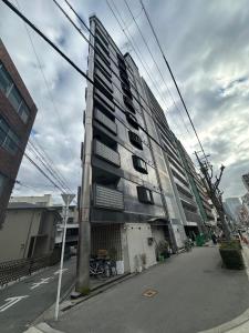 a tall building on the side of a street at Panda Home Umeda 01 in Osaka