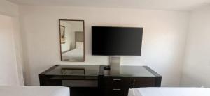 a flat screen tv on a desk in a hotel room at Hotel Palmas Quintero in Rosarito Beach