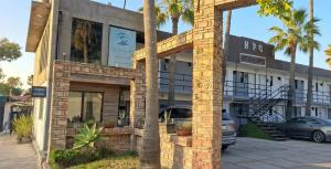 a building with a car parked in front of it at Hotel Palmas Quintero in Rosarito Beach