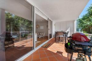 a house with a balcony with a view of a patio at Sophisticated & stylish beachside apartment with pool in Sunrise Beach