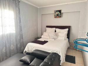 a bedroom with a bed with a leather couch at 399 Place in Umtali