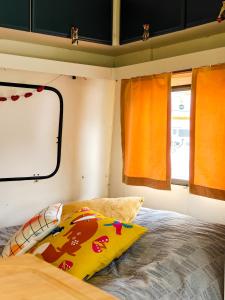 a bed in a small room with orange curtains at Camper Somá in Muonio