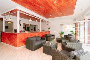a lobby with a bar with couches and chairs at Hotel Alexandros in Ammoudia