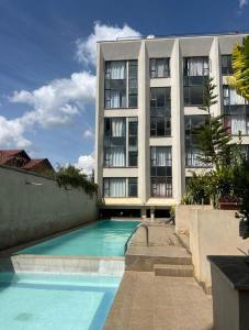 a building with a swimming pool in front of a building at Imanis comfort in Ongata Rongai 