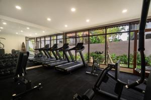 a gym with a row of treadmills and ellipticals at Sarva Ubud Villas & Spa in Ubud