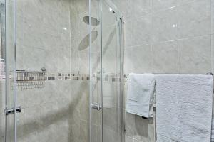 a shower with a glass door in a bathroom at Elyon Suites in Kempton Park +23 photos