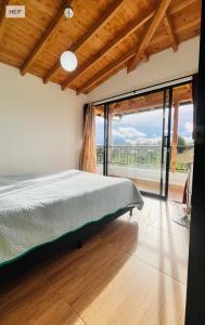 a bedroom with a bed and a large window at Apartamento La bonita guatape in Guatapé