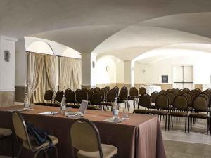 a conference room with tables and chairs and a laptop at Borgobianco Resort & Spa Polignano - MGallery Collection in Polignano a Mare +114 photos