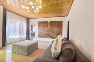 a living room with a couch and a brick wall at Elyon Suites in Kempton Park