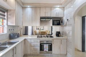 a kitchen with wooden cabinets and a stove top oven at Elyon Suites in Kempton Park