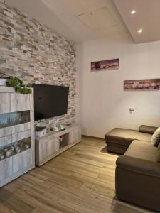 a living room with a flat screen tv and a couch at MaGi-A apartment in Cecina