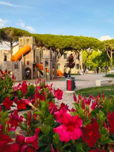 a park with a playground with flowers in the foreground at MaGi-A apartment in Cecina