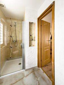 a bathroom with a shower and a glass door at Domek Zyngierka Tatra View - balia I sauna na wyłączność in Bańska Wyżna