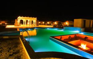 a swimming pool at night with a building in the background at Royal Salma Resort A family Luxury Camp 