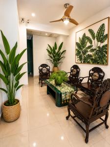a living room with chairs and a table and plants at Sun Inns Skudai in Skudai