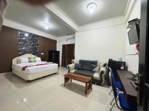 ein Wohnzimmer mit einem Bett und einer Couch in der Unterkunft Leokase Hotel in Dili