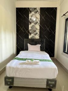 Ein Schlafzimmer mit einem weißen Bett und einer schwarzen Wand in der Unterkunft Leokase Hotel in Dili