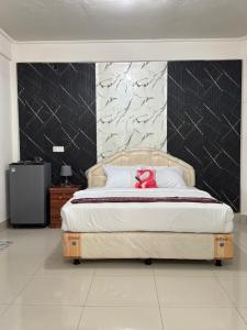 ein Schlafzimmer mit einem Bett, auf dem ein Teddybär liegt in der Unterkunft Leokase Hotel in Dili