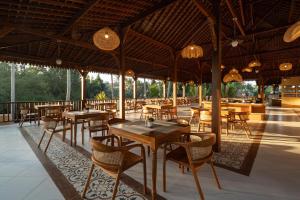 a restaurant with tables and chairs on a patio at Sarva Ubud Villas & Spa in Ubud